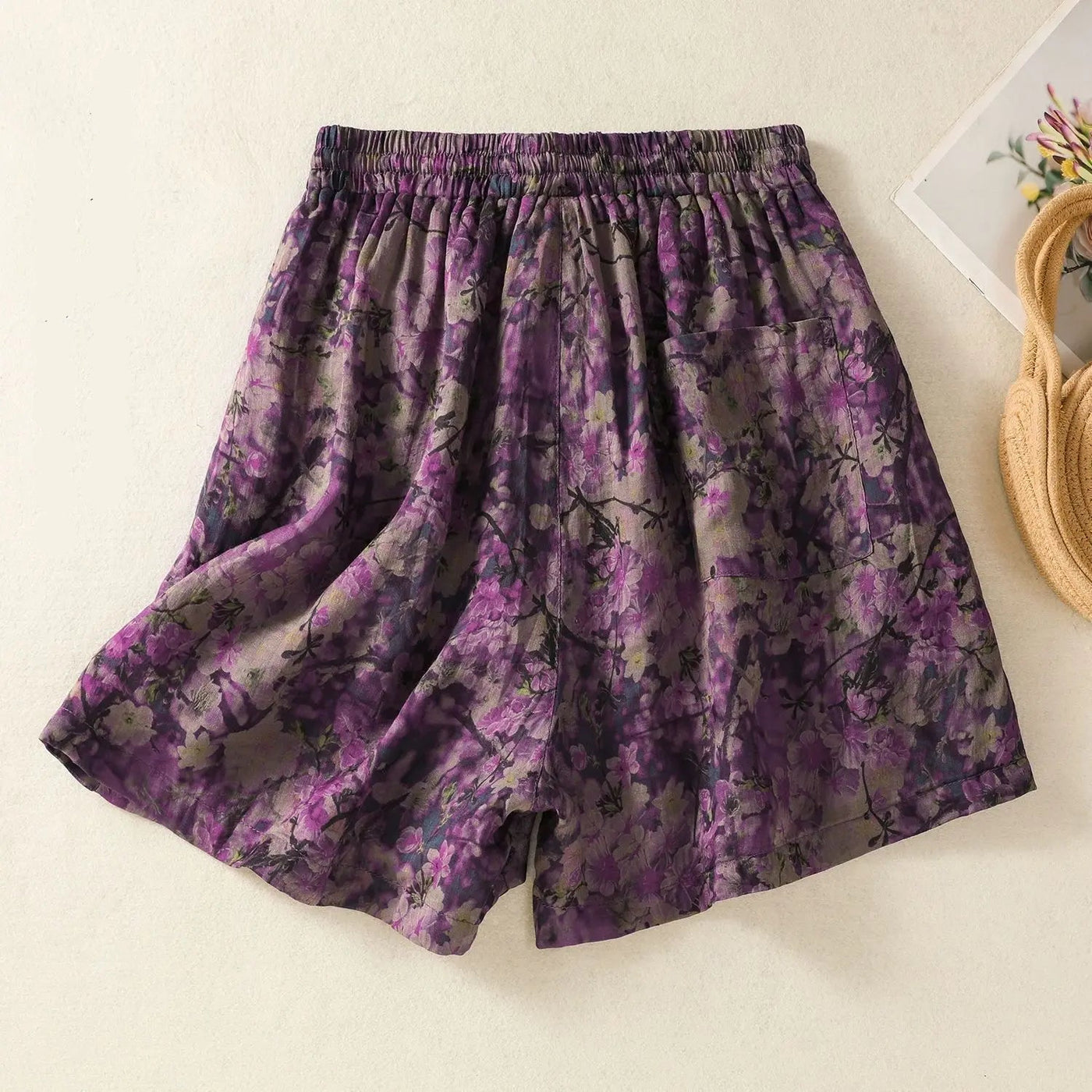 Purple floral shorts on a light beige background