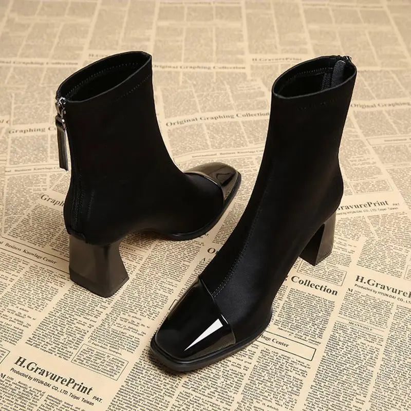 Black high-heeled boots on a newspaper background