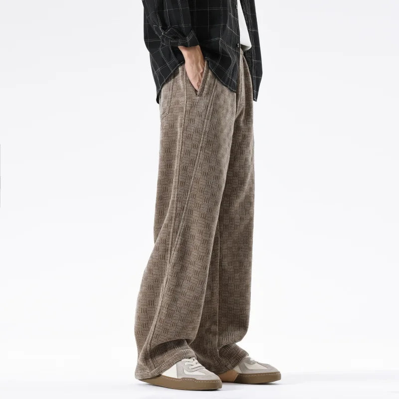 Person wearing brown plaid pants and a black and white checkered shirt on a white background