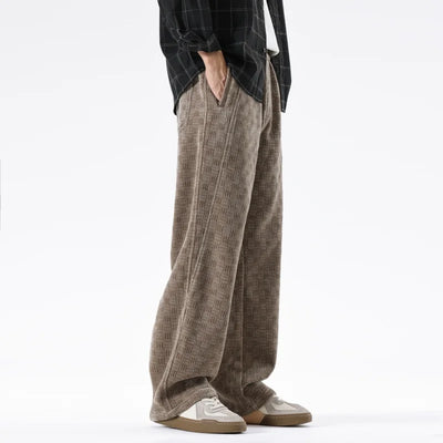 Person wearing brown plaid pants and a black and white checkered shirt on a white background