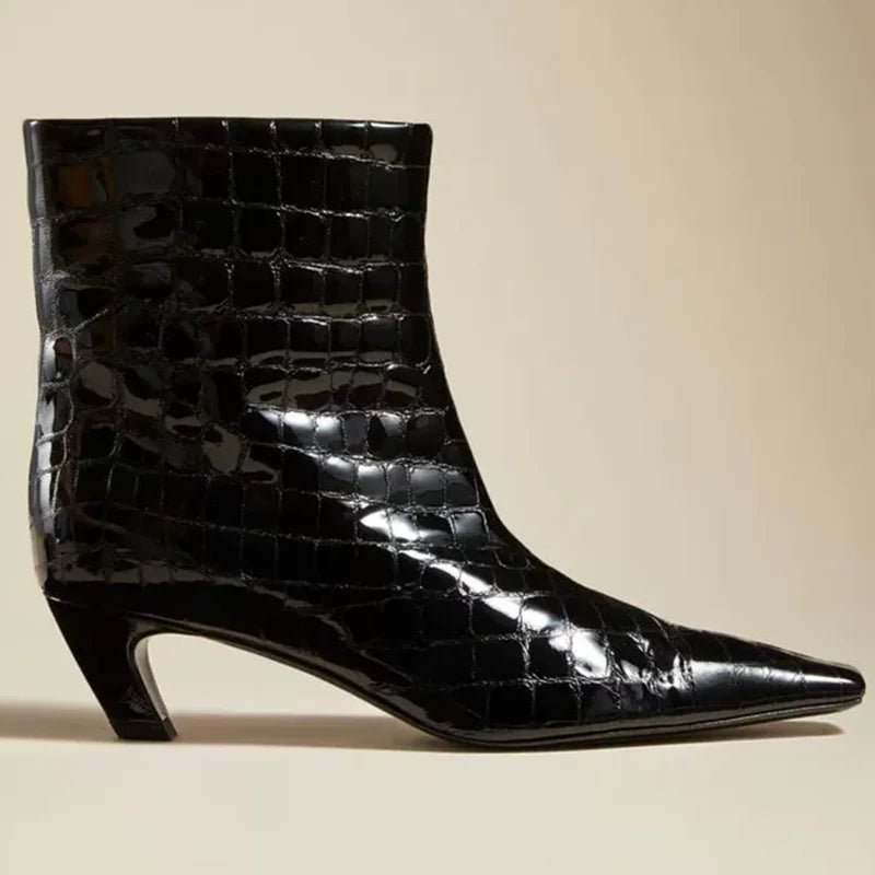 Black crocodile-patterned ankle boot on a beige background