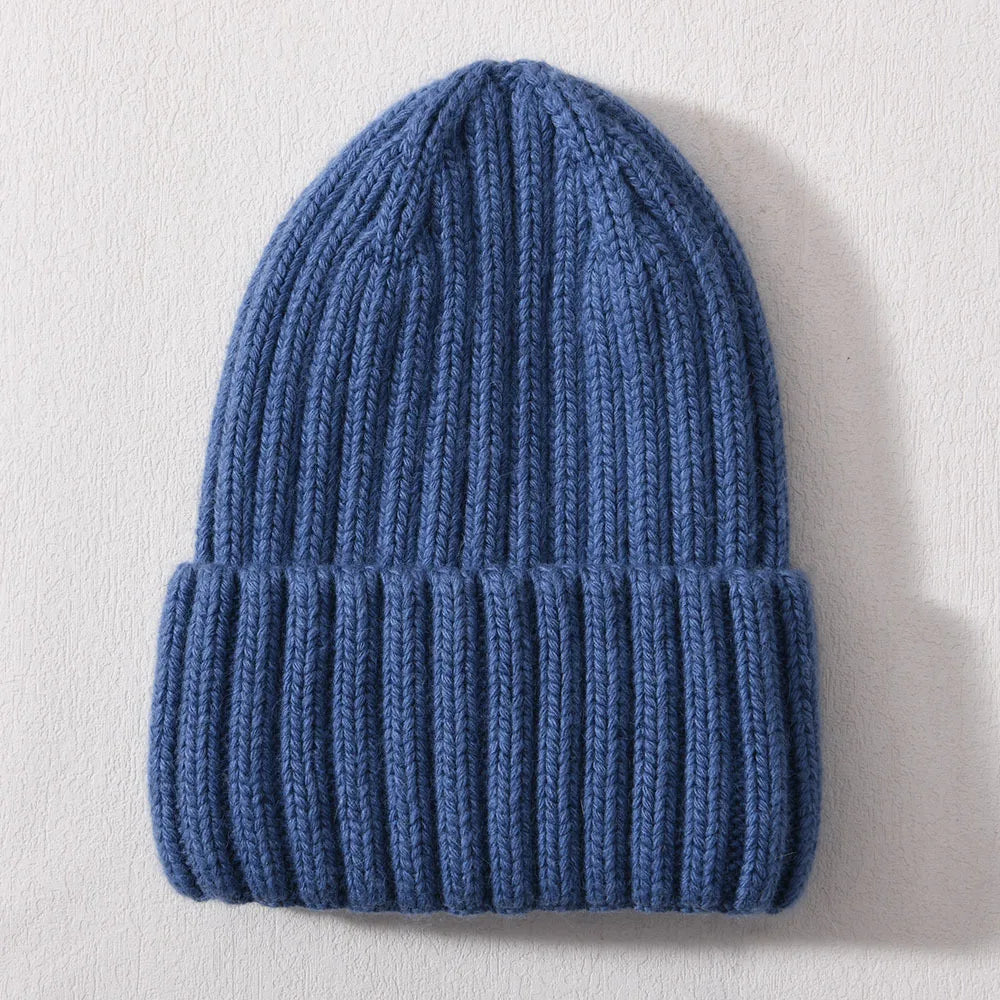 Blue knitted beanie on a light gray background